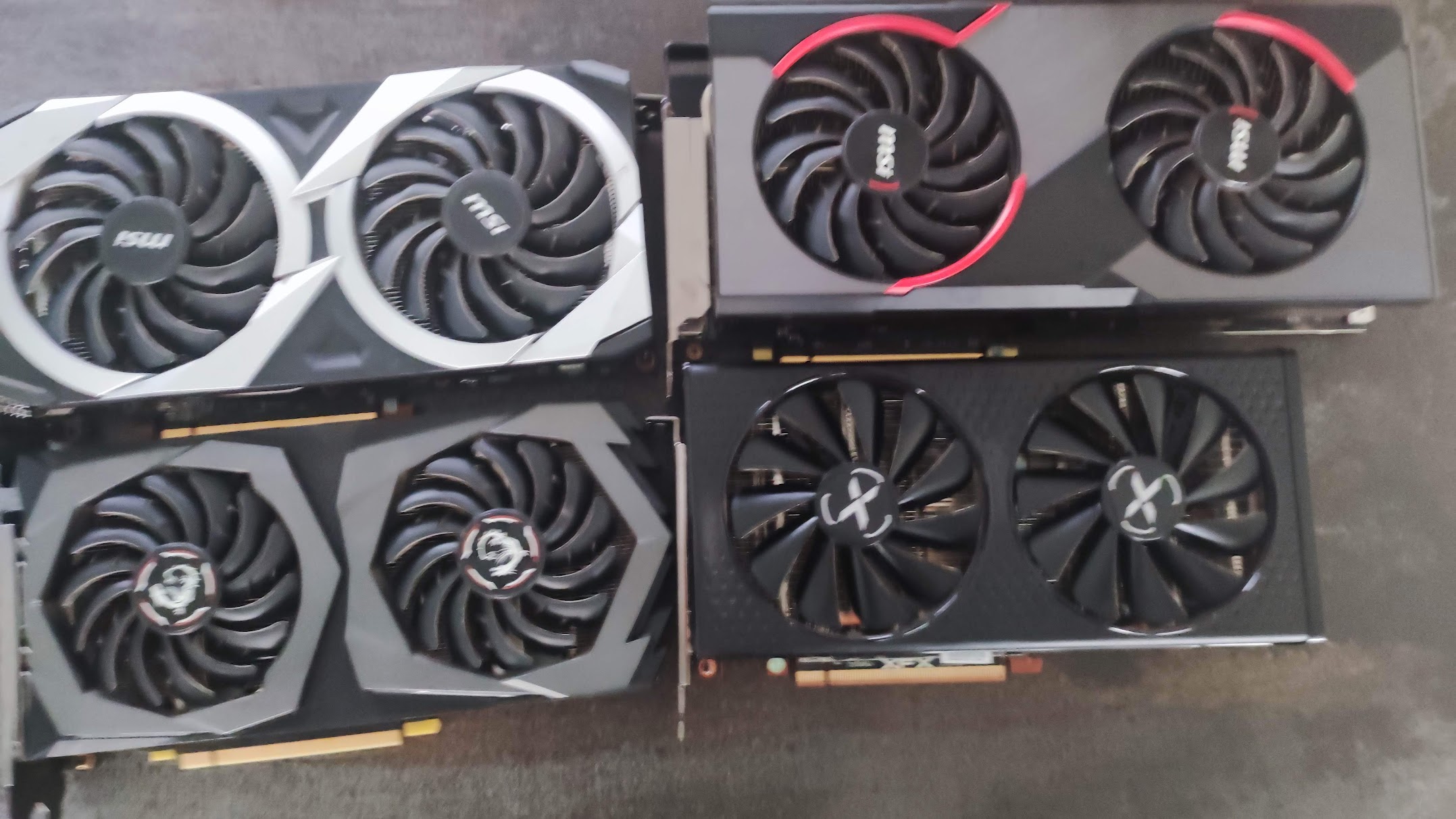 Four graphics cards laid out on a concrete floor